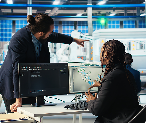 Technology professionals reviewing cybersecurity systems in a manufacturing facility